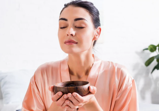 Woman smelling the aroma from a bowl, aromatherapy recipes to sleep better, feel calmer
