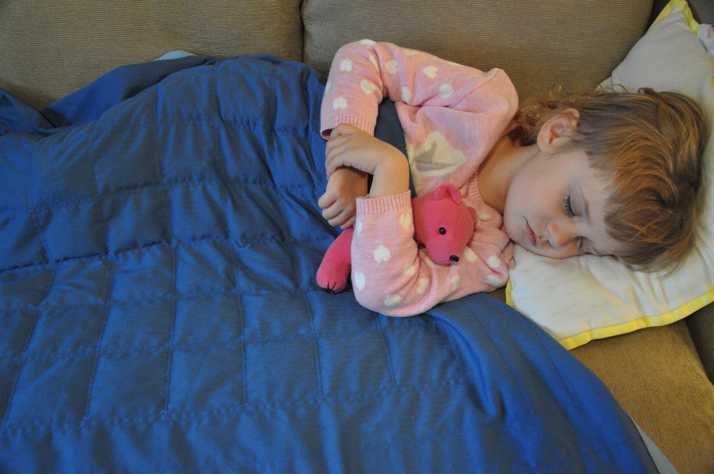 Infrared Health Blanket for Kids Product Image. Child taking a nap on the couch with a SleepGift blanket.